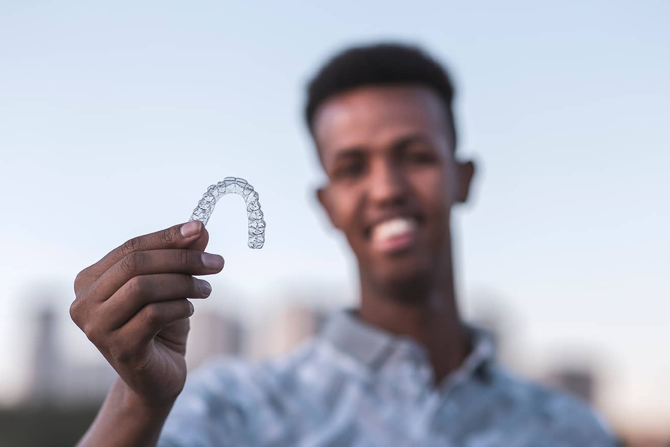 man holding up invisalign dental aligners in Fruit Cove, FL