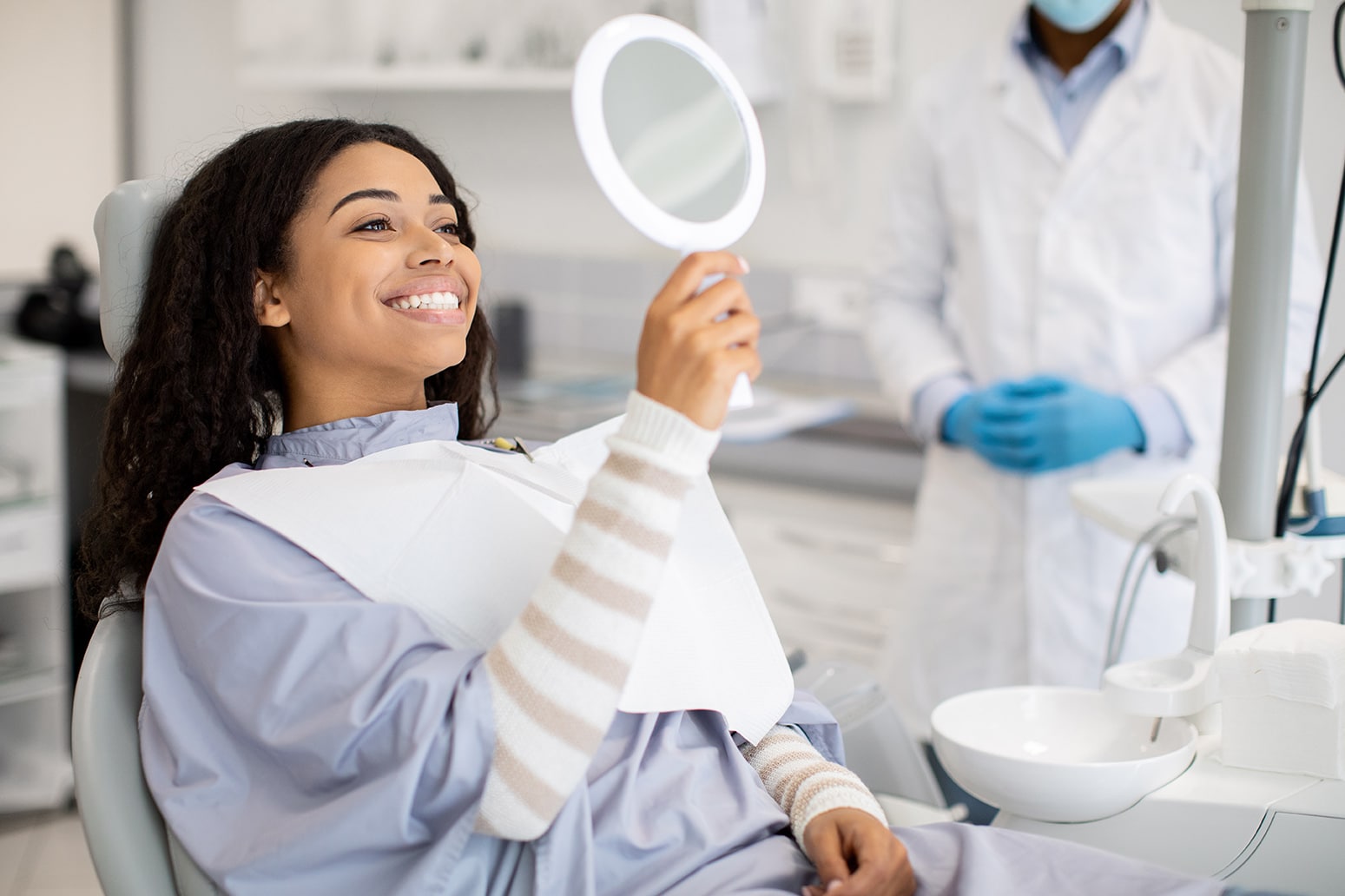 female dental patient looking into a mirror during composite dental bonding appointment at vivere meliora